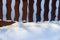 Snowdrift under a fence