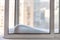 Snowdrift on window casement and cityscape