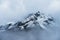 Snowed Mountain peaks hidden in clouds in Himalayas