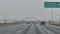 Snowfall on American Interstate Highway. Cars Moving Slowly on Snowy Winter Day