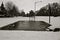 Snowfall on a basketball court with melting on the concrete black and white