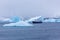 Snowfall and cruise liner among blue icebergs in Port Charcot, B