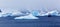 Snowfall and cruise ship among blue icebergs in Port Charcot, Bo