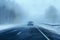Snowfall and dense fog reduce visibility on the winter highway