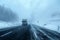 Snowfall and dense fog reduce visibility on the winter highway