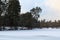 Snowfall in the forest. Amazing winter landscape of frozen pond in the forest. Evergreen wood and shore in snow.