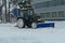 Snowfall. Machines for cleaning snow. The tractor removes snow on the roads of the city. Winter cyclone.