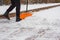 After a snowfall, a man clears snow from the road in winter, work in the winter season