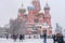 Snowfall in Moscow.People enjoying winter weather walking up and down on Red Square next to St. Basil`s Cathedral