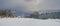 Snowfall over countryside hills, groves and farmlands in winter remote alpine mountain village