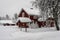 Snowfall in the village. Blurred background. Old wooden house in the snow. Traditional typical Scandinavian Swedish house or villa