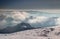 Snowfield with signposts in Velka Fatra ridges above blue mist