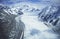 Snowfield in valley between snow-covered mountains