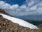 Snowfields on a mountain slope. Dangerous cliff. Atmospheric scenery on top of mountain ridge. Snowy high-altitude plateau. Scenic