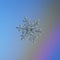 Snowflake glittering on light blue background