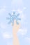 Snowflake in hand. Shiny blue snowflake. Snowflake in sparkles. Winter illustration. Vector