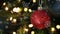 Snowflakes falling against close up view of red bauble decorations hanging on christmas tree