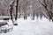 Snowing landscape in the park with people passing by