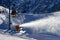 snowmaking cannon sprays snow on the ski slope