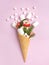 Snowman, Christmas tree twigs and lollipop in a waffle cone. Pink background. An original sweet gift. Christmas card