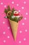 Snowman, Christmas tree twigs and lollipop in a waffle cone. Red background with snowflakes. An original sweet gift