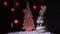 The snowman dances a round dance around a Christmas fir-tree against the background of colourful fires