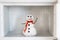 Snowman in empty freezer. Buildup of ice, cleaning and servicing concept. Funny diet idea