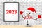 Snowman in front of Brick Wall with Frame 2023 Sign. 3d Rendering