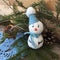 Snowman handmade toy on a spruce branch