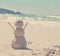 Snowman made of sand on a background of the tropical warm sea