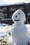 Snowman stand on white snowground