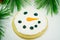 Snowman sugar cookie with greenery. Sweet holiday treat. Dessert cookie for the holidays.