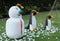 Snowman and three penguins on a green lawn, garden sculpture