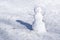 Snowman on white background. Green grass growing. First snow.