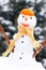 Snowman with woolen scarf and tangerine peel, winter season concept