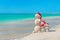 Snowmans family at sea beach in santa hat.