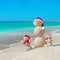 Snowmans family at sea beach in santa hat.