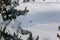 The snowmobile climbs up the slope of the mountain through an snow field