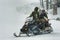 Snowmobile gives snowboarder a lift