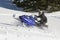 Snowmobile riderracing through snow in mountains