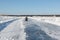 Snowmobile riding along ice road on a frozen reservoir