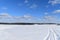 Snowmobile tracks under a blue sky