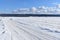 A snowmobile trail under a blue sky