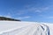 A snowmobile trail under a blue sky