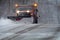 Snowplow in action clearing residential roads during snow storm