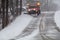 Snowplow in action clearing residential roads during snow storm
