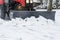 Snowplow removes snow from the sidewalk during a snowfall
