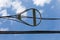 Snowshoe fiber optic radius limiter alongside overhead power lines against blue sky with clouds