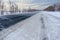 Snowstorm on the highway. Patterns on the winter highway in the form of four straight lines. Snowy road on the background