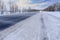 Snowstorm on the highway. Patterns on the winter highway in the form of four straight lines. Snowy road on the background of snow-